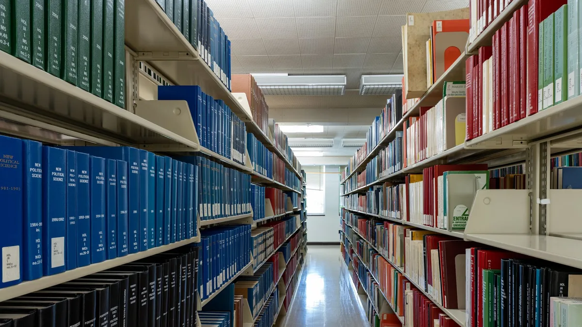 Wide aisle of bookshelves in an academic library at Washington State University.